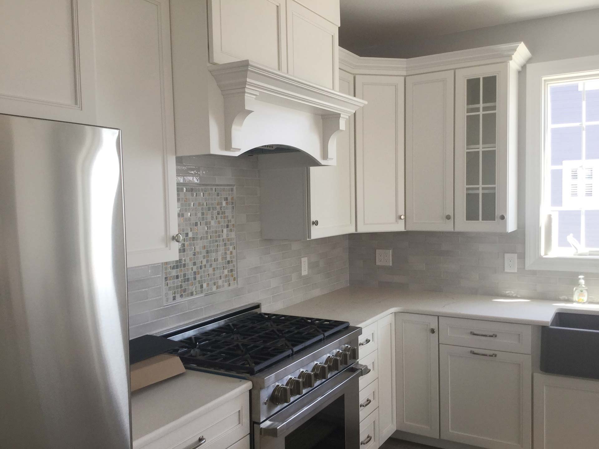 White kitchen cabinets and custom vent hood